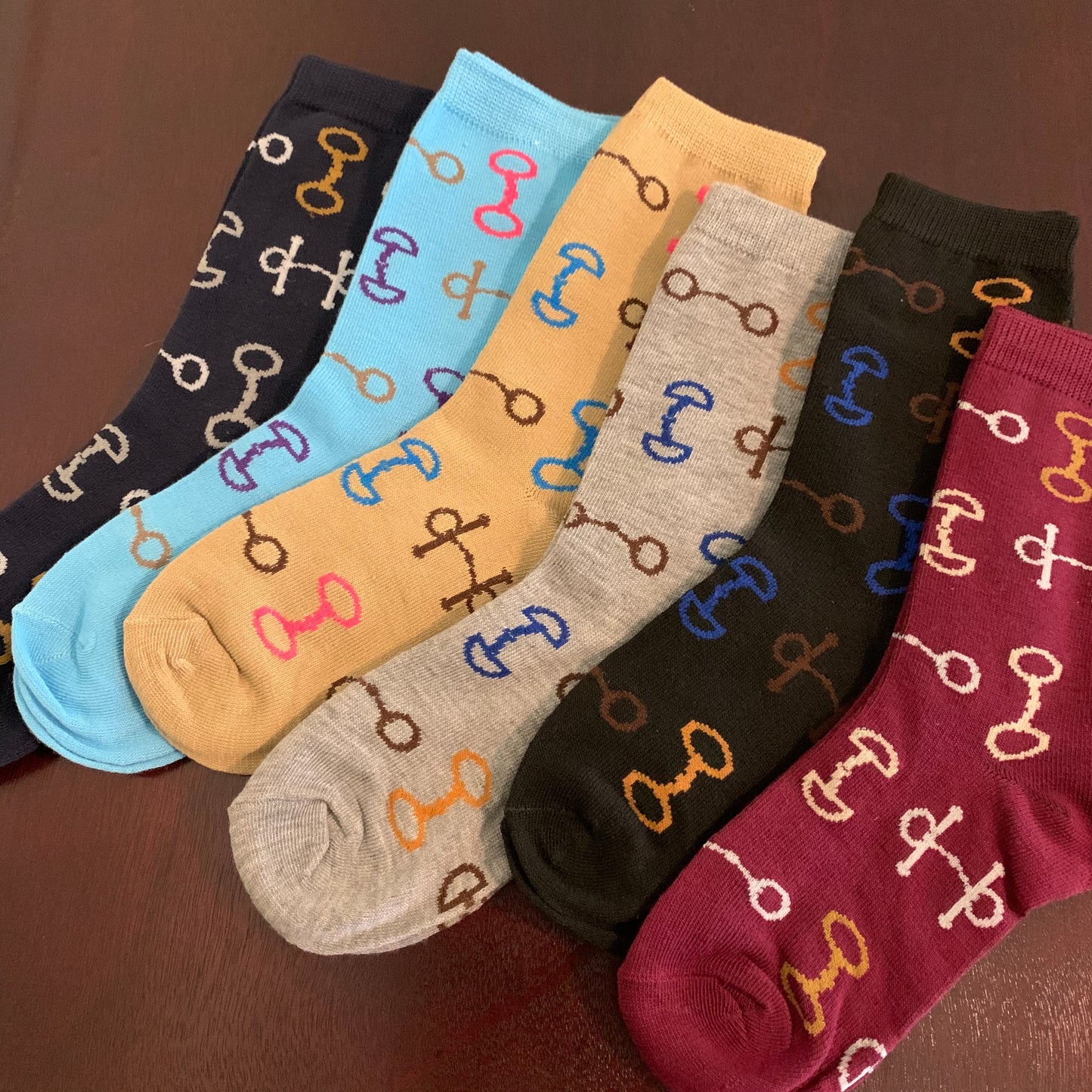 Socks in Maroon Black Grey Tan Aqua and Navy Laying Flat with Multi-Color Snaffle Bits in White Brown Gold Blue and Pink